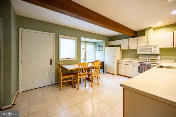 a dining room with furniture and a kitchen view