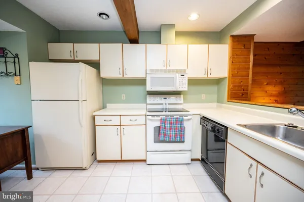a kitchen with a refrigerator a stove top oven and a sink
