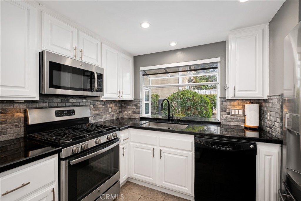 7 Oak Spring Lane, Unit 319 Aliso Viejo, CA 92656 - Photo 11 of 37 a kitchen with stainless steel appliances a stove sink microwave and cabinets