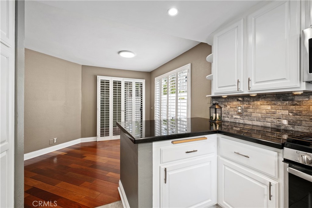 7 Oak Spring Lane, Unit 319 Aliso Viejo, CA 92656 - Photo 12 of 37 a kitchen with granite countertop white cabinets and white appliances