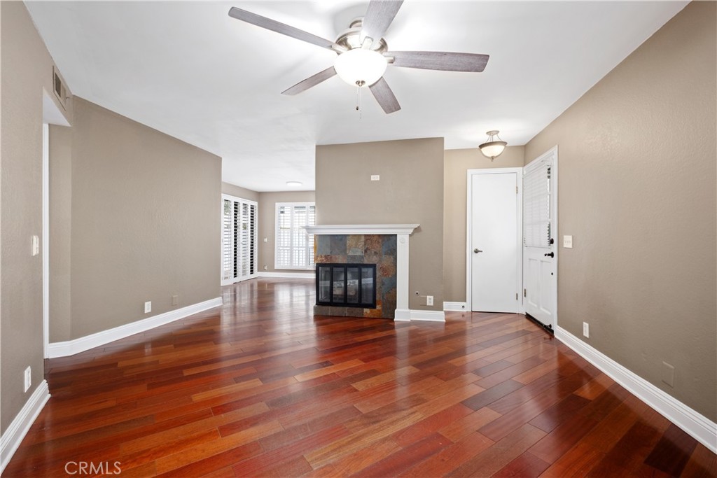 7 Oak Spring Lane, Unit 319 Aliso Viejo, CA 92656 - Photo 4 of 37 an empty room with wooden floor fireplace and a window