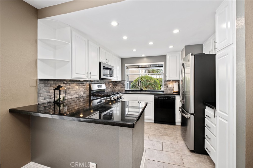 7 Oak Spring Lane, Unit 319 Aliso Viejo, CA 92656 - Photo 9 of 37 a kitchen with stainless steel appliances granite countertop a refrigerator a stove a sink and a microwave
