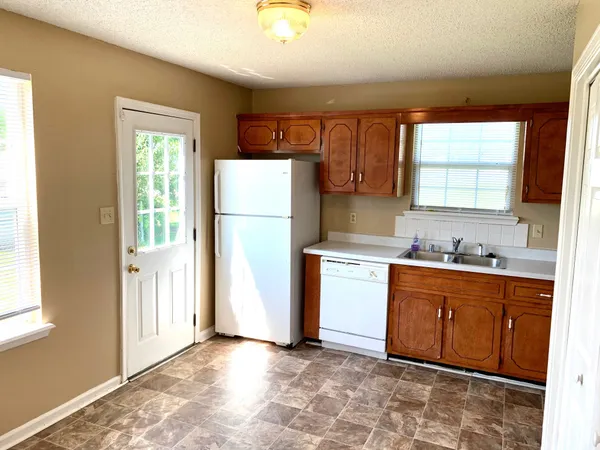 a kitchen with a refrigerator sink stove and cabinets