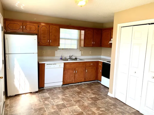 a kitchen with a refrigerator sink and cabinets