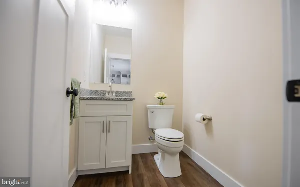 a bathroom with a granite countertop toilet and a sink