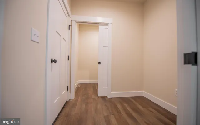 a view of a room with wooden floor and a hallway