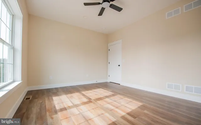 wooden floor in an empty room with a window