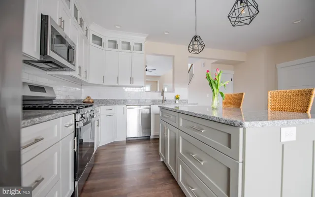 a kitchen with stainless steel appliances granite countertop a stove a sink and a refrigerator