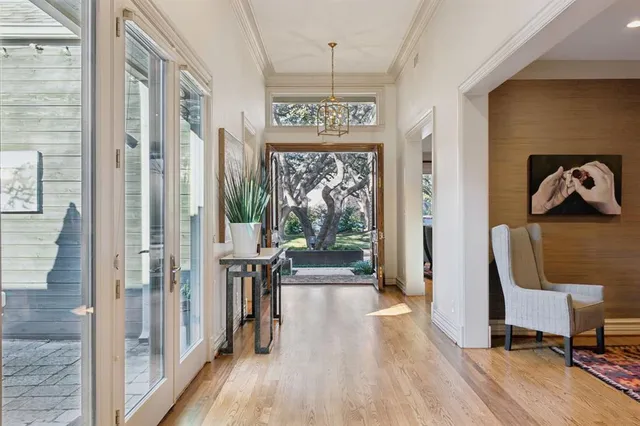 a view of a hallway with wooden floor and windows