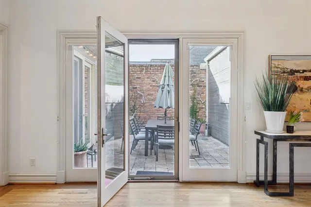 a view of a livingroom with wooden floor and a glass door