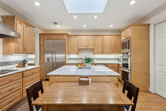a kitchen with kitchen island stainless steel appliances a sink stove and refrigerator