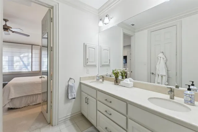 a spacious en suite bathroom with a double vanity sink and mirror