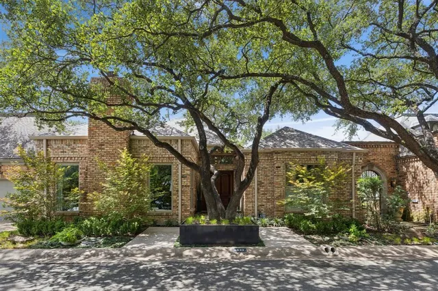 a front view of a house with a tree