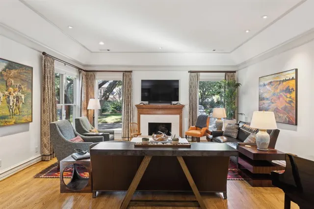 a living room with furniture fireplace and a large window