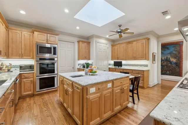 a kitchen with kitchen island a stove a sink and a refrigerator