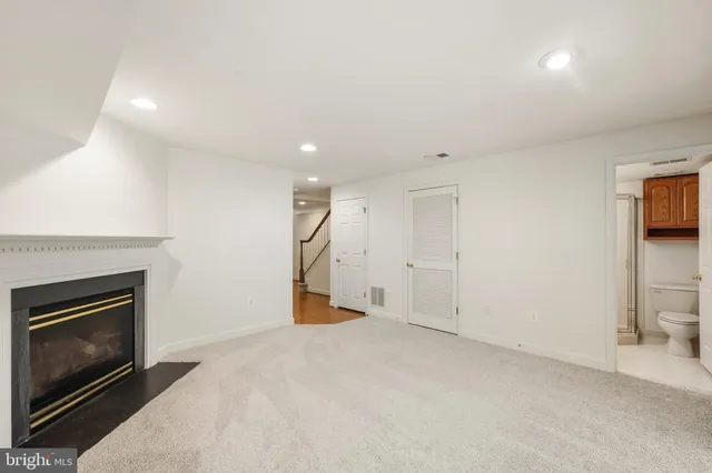 an empty room with a fireplace and large window