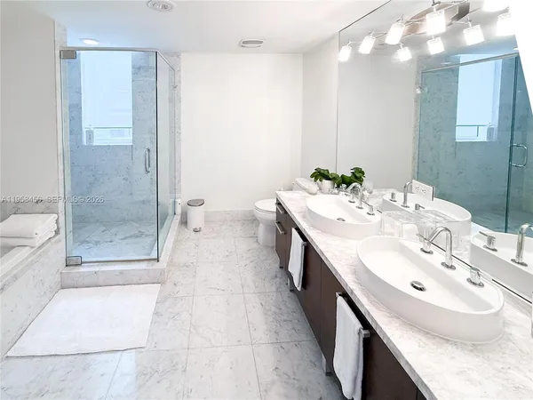 a bathroom with a double vanity sink mirror and shower
