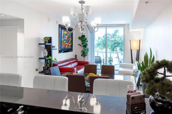 a living room with furniture a chandelier and a large window
