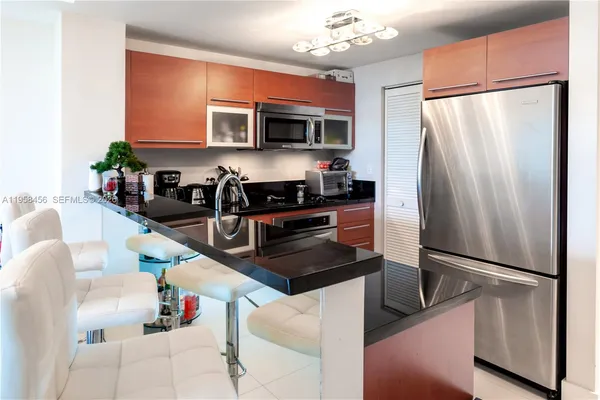 a kitchen with stainless steel appliances granite countertop a refrigerator sink and microwave