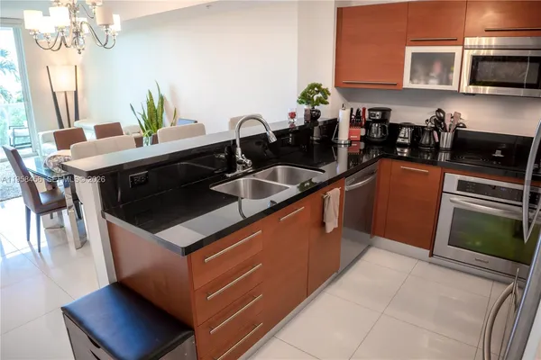 a kitchen with stainless steel appliances granite countertop a sink a stove a microwave a counter top space and cabinets