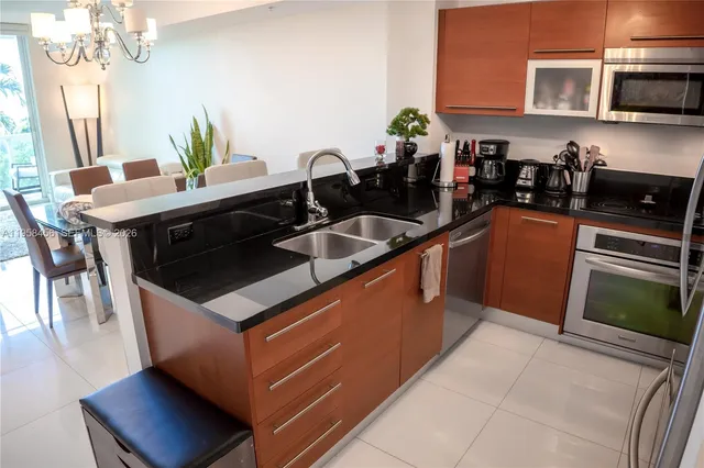 a kitchen with stainless steel appliances granite countertop a sink a stove a microwave a counter top space and cabinets