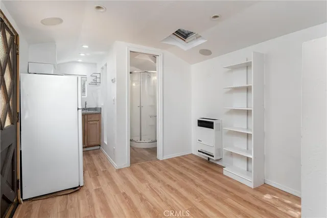 a view of empty room with wooden floor and window