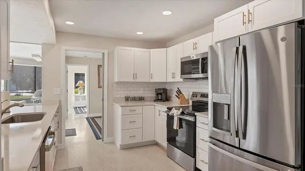 a kitchen with white cabinets and sink