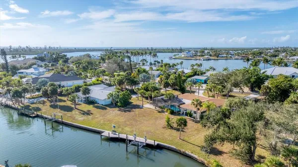 an aerial view of residential houses with outdoor space and lake view
