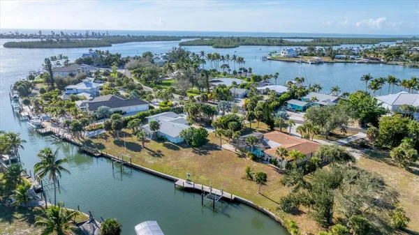 an aerial view of lake and residential houses with outdoor space and swimming pool