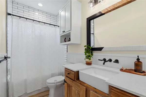 a bathroom with a sink a toilet and shower curtain