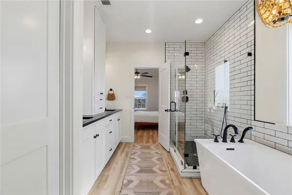 a bathroom with a tub sink and mirror