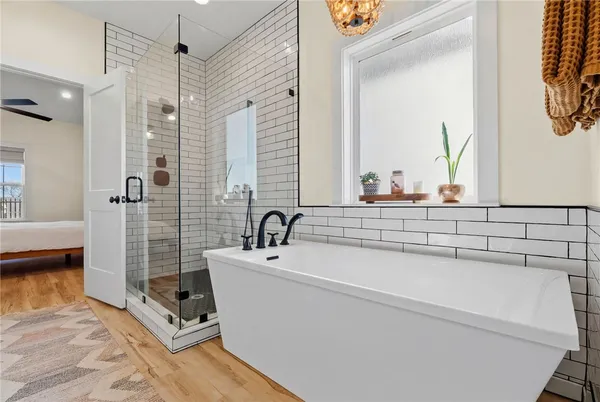 a bathroom with a tub a sink and a mirror
