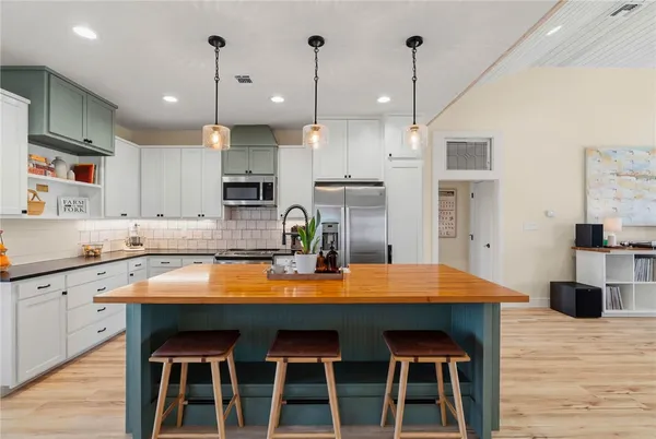 a kitchen with kitchen island a sink stove and refrigerator