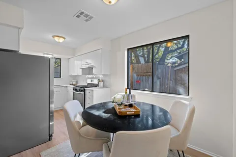 a kitchen with a table chairs and refrigerator