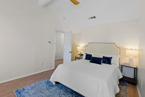 a bedroom with a bed and wooden floor