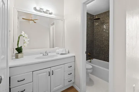 a bathroom with a granite countertop sink a toilet and shower
