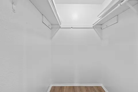 a view of walk in closet with clothes