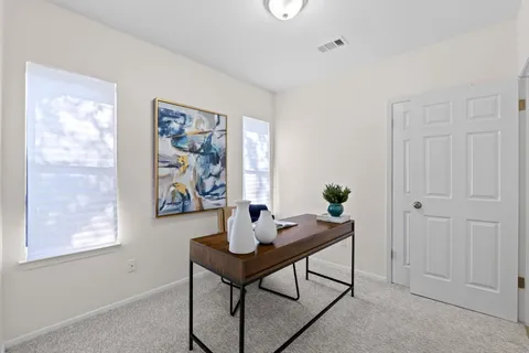 a view of a workspace with furniture and window