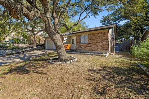 a view of a house with backyard and trees