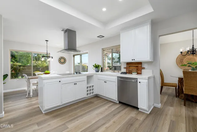 a kitchen with white cabinets and wooden floor