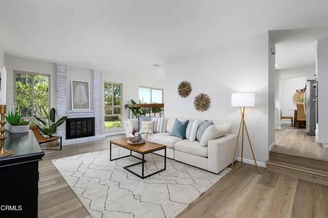 a living room with furniture a fireplace and a large window