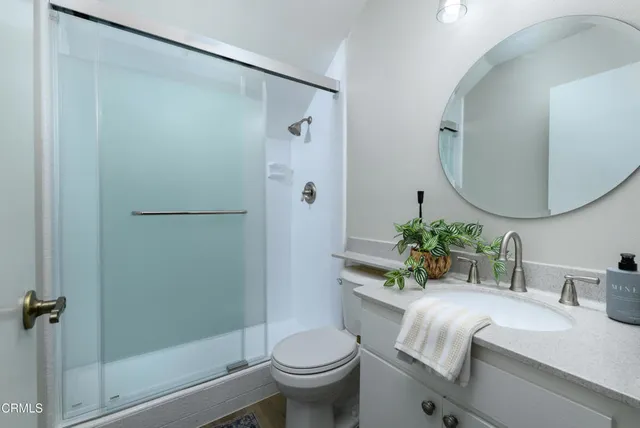 a bathroom with a granite countertop sink toilet a large mirror and shower