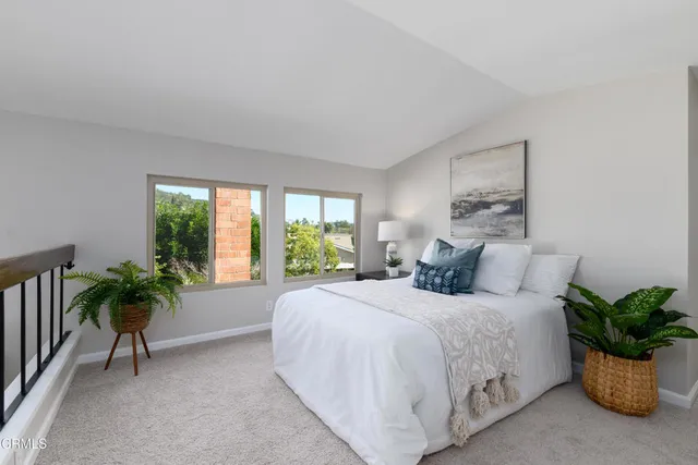 a bedroom with a bed and a potted plant