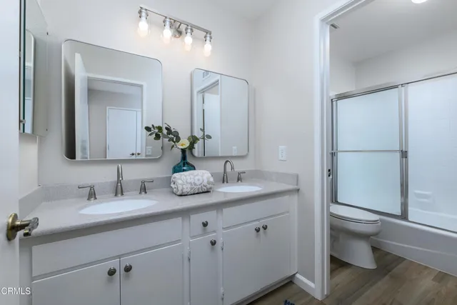 a bathroom with a granite countertop sink mirror and toilet