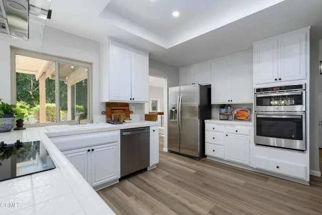 a kitchen with granite countertop a refrigerator and a stove top oven