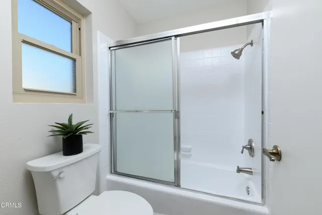 a bathroom with a shower a toilet and a sink