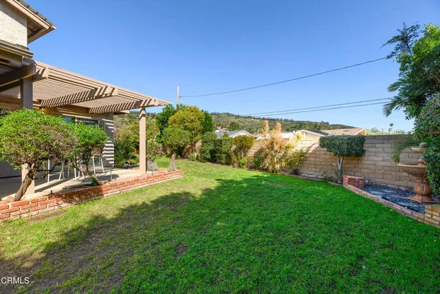 a view of a patio with table and chairs under an umbrella