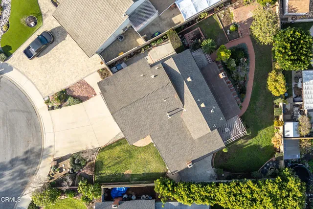 an aerial view of a house with a yard and a large tree