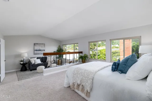 a bedroom with a bed couch and large window