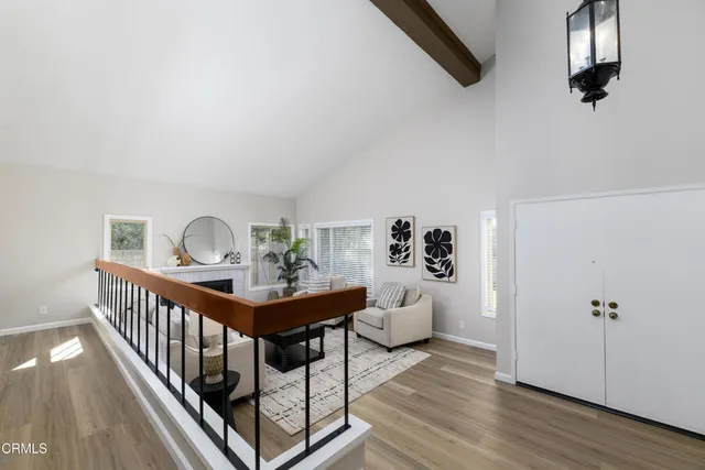a view of a hallway with wooden floor and windows